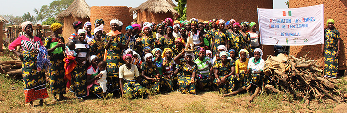 A group of female cotton farmers standing together for a group picture, Olam.