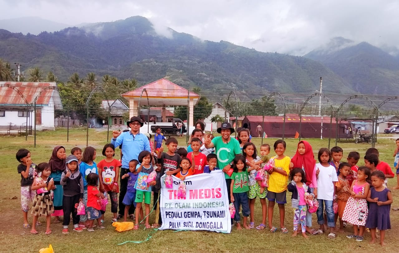 A group of children standing together outside a rural school sponsored by Olam, Indonesia.